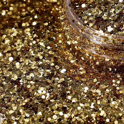 Close-up of gold glitter with a jar lid in the background