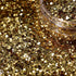 Close-up of gold glitter with a jar lid in the background