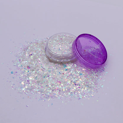 Iridescent glitter with a purple container on a light gray background