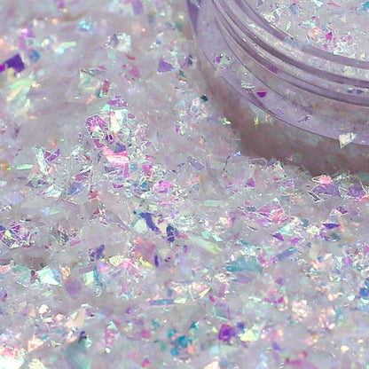 Iridescent glitter on a white background with a container of glitter.