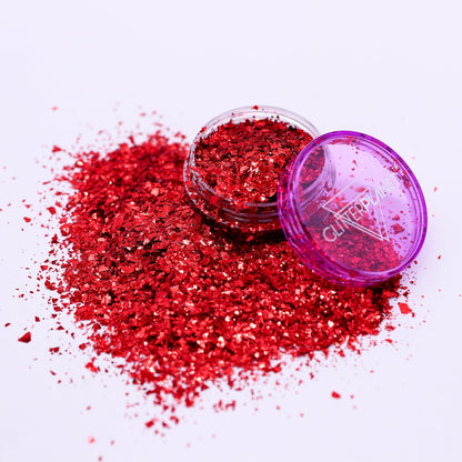 Red glitter with a purple lid on a white background