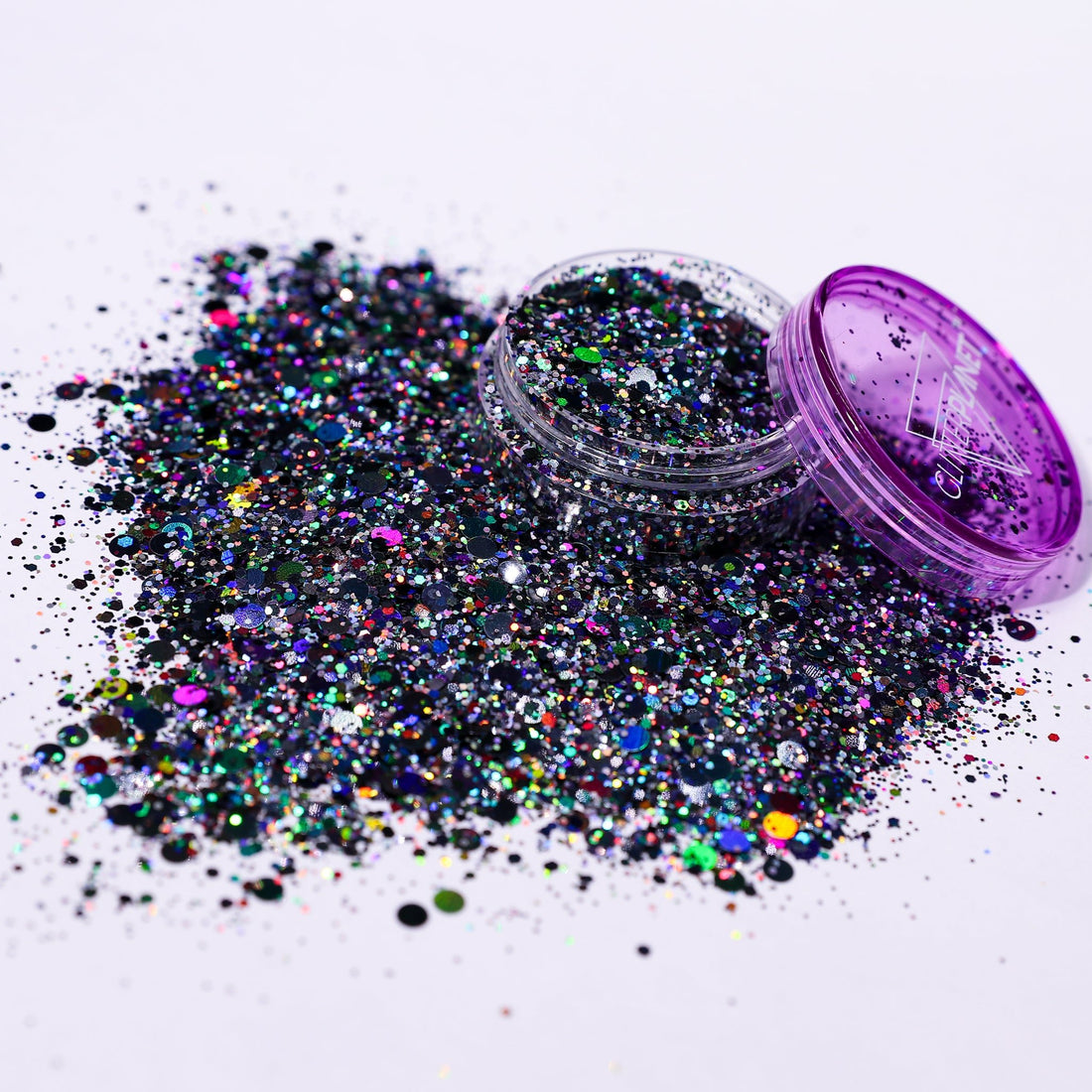 Multicolored glitter spilling out of a purple container on a white background