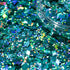 Turquoise glitter with a clear container on a dark background