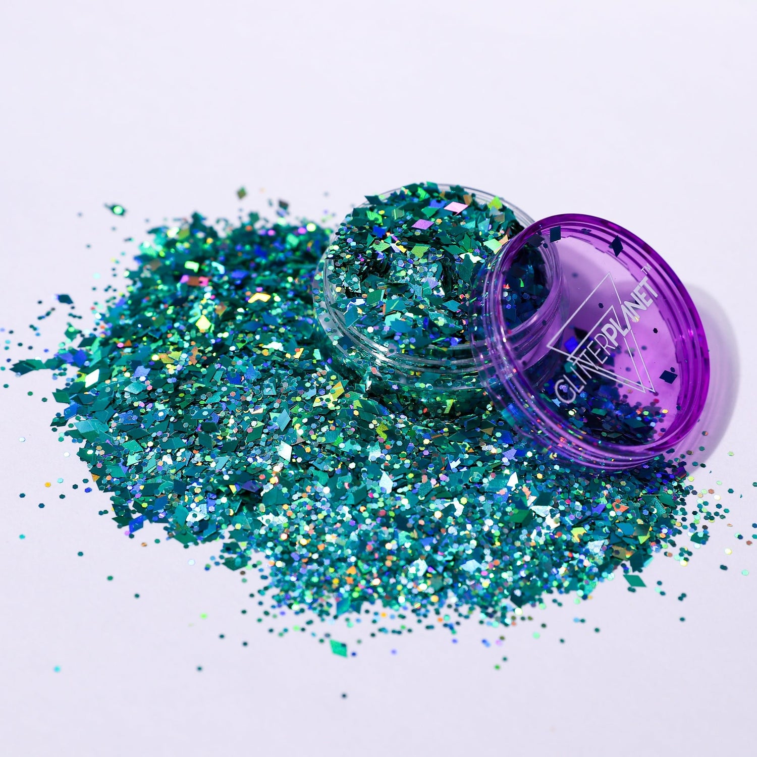 Turquoise glitter spilling out of a purple container labeled &