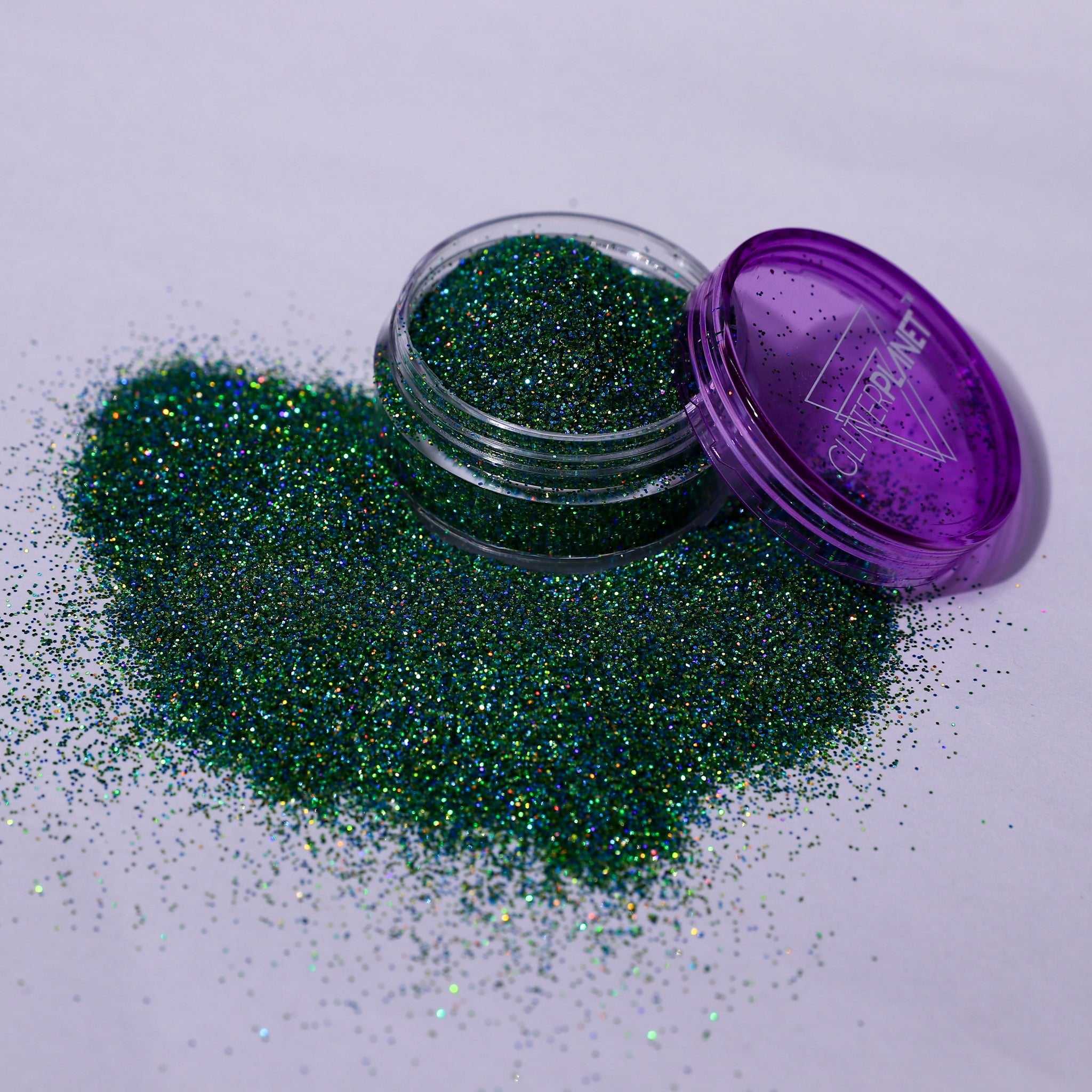 Green glitter spilling out of a purple container labeled &