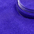 navy blue glittery powder with a container on a purple background