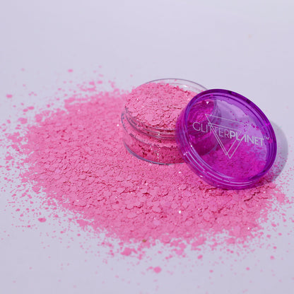 Pink glitter powder with a purple container on a white background