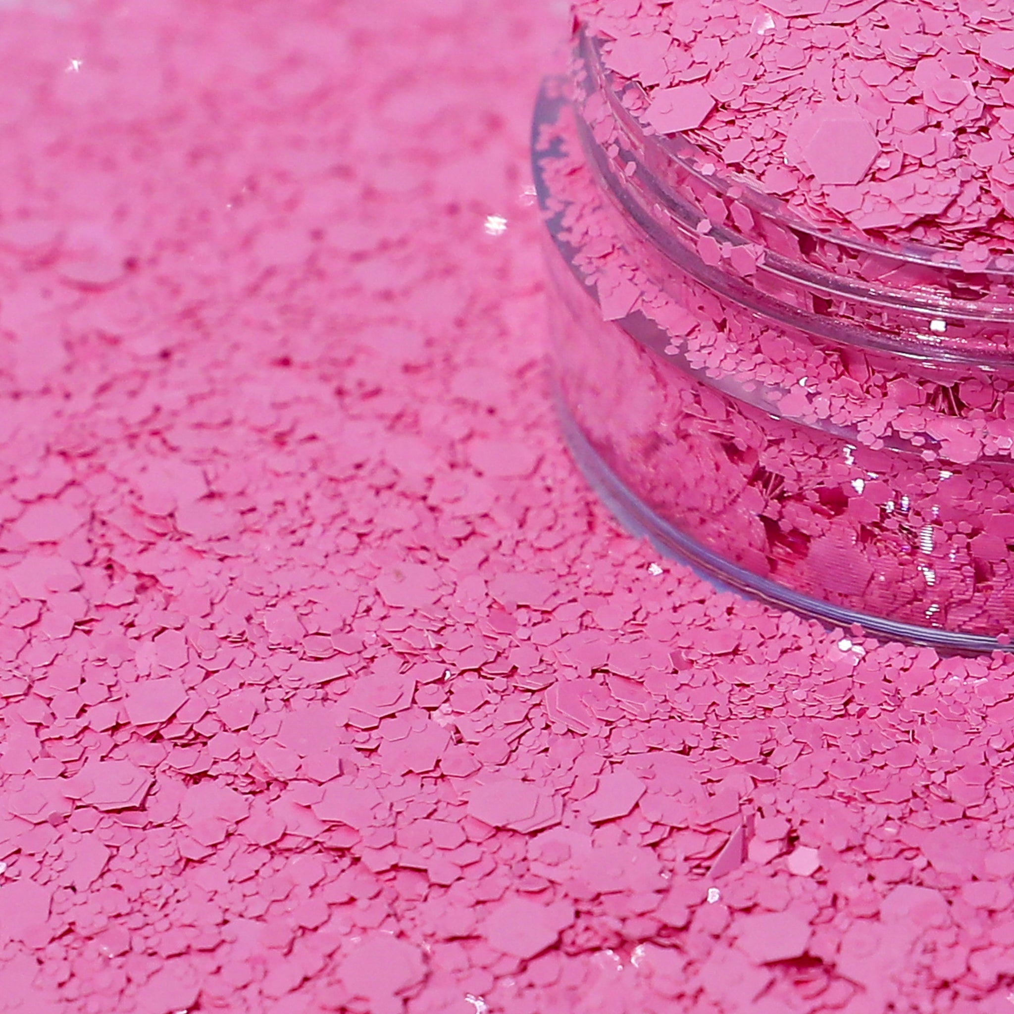 Pink glitter in a clear jar spilled out.
