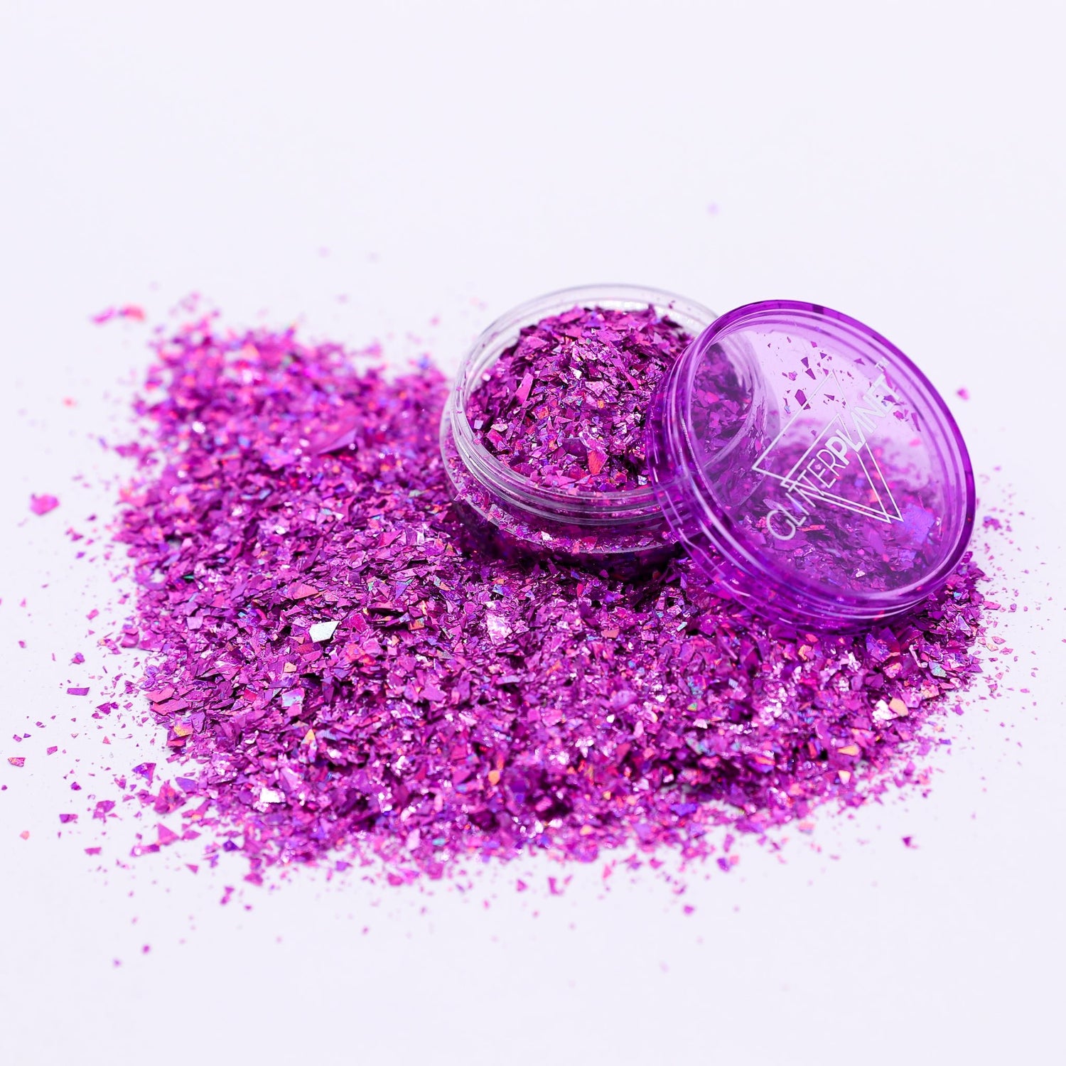 Purple glitter with a open container on a white background