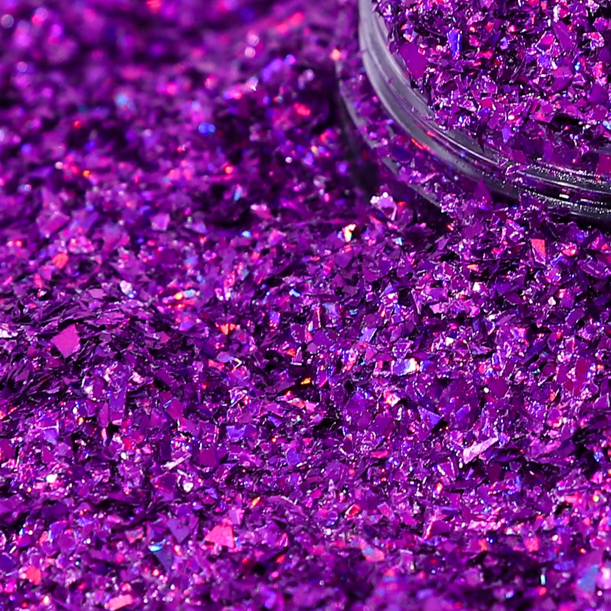 Purple glitter with a clear container partially filled with glitter.