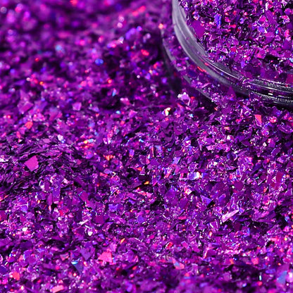 Purple glitter with a clear container partially filled with glitter.