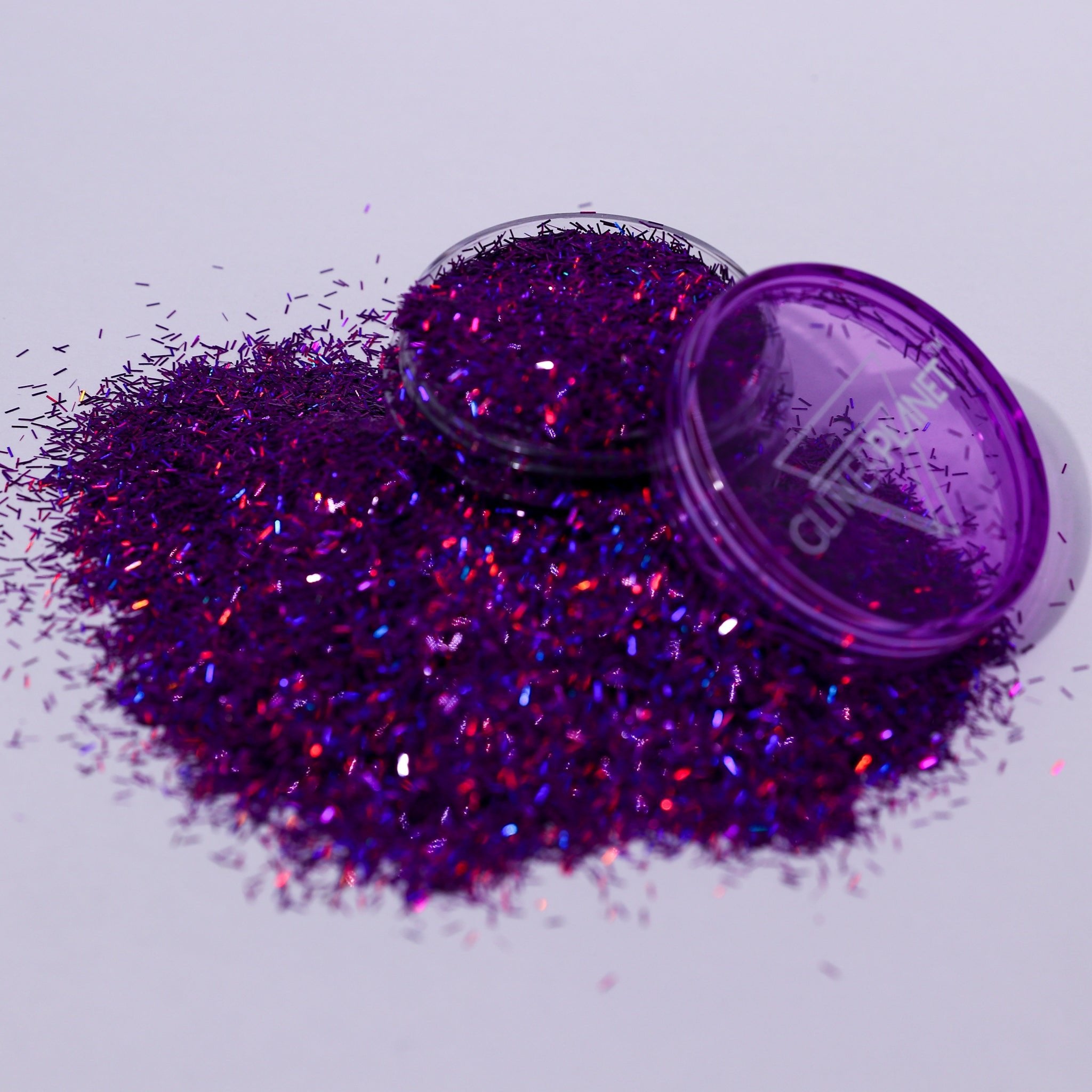 Purple glitter with a closed container on a light gray background
