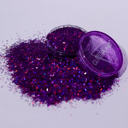 Purple glitter with a closed container on a light gray background