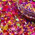 Colorful glitter with a clear container on a multicolored background