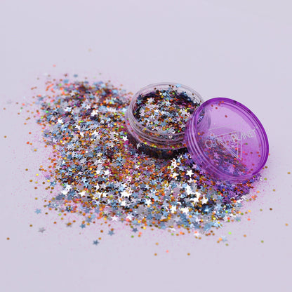 Multicolored glitter spilling out of a purple container on a light gray background