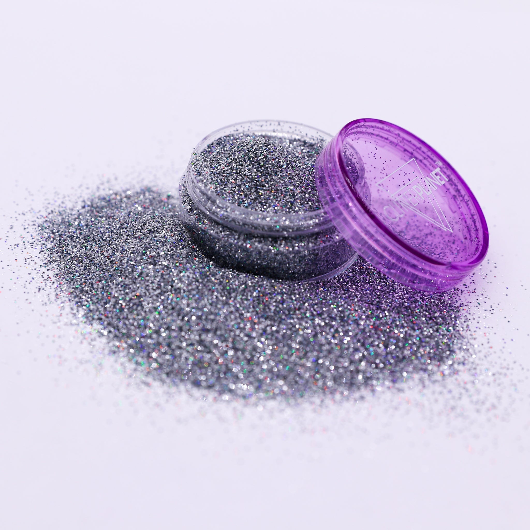 Silver glitter with an open purple container on a white background
