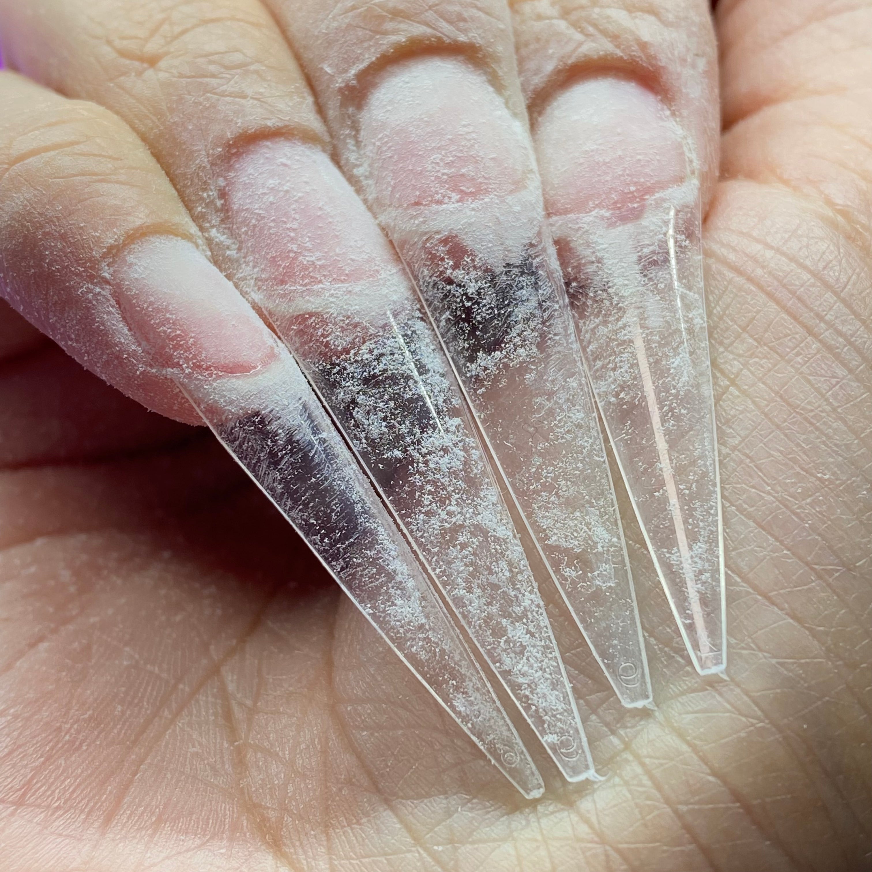 natural nails with long clear stiletto nail tips applied and filed into shape