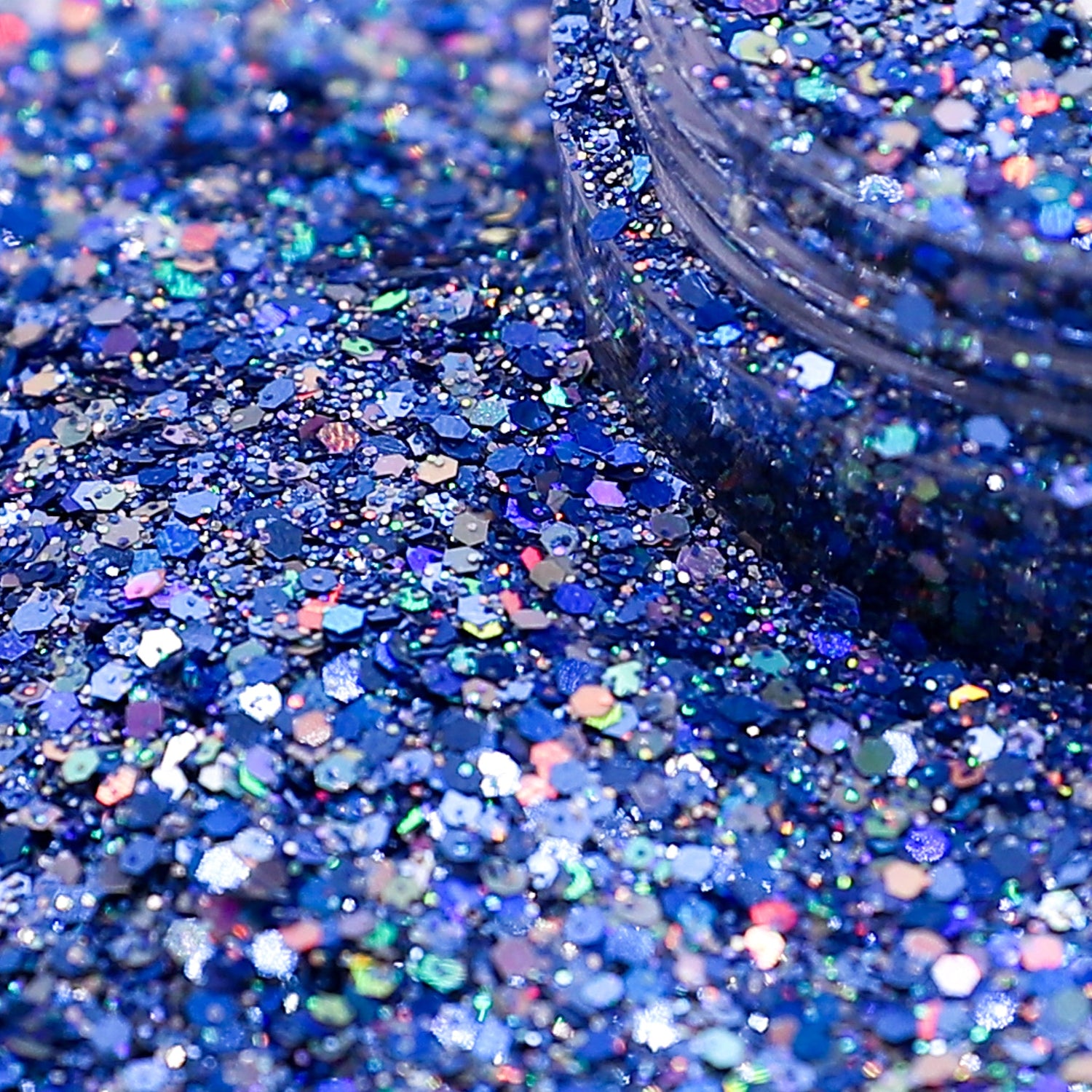 Close-up of blue glitter with a jar partially filled with glitter.