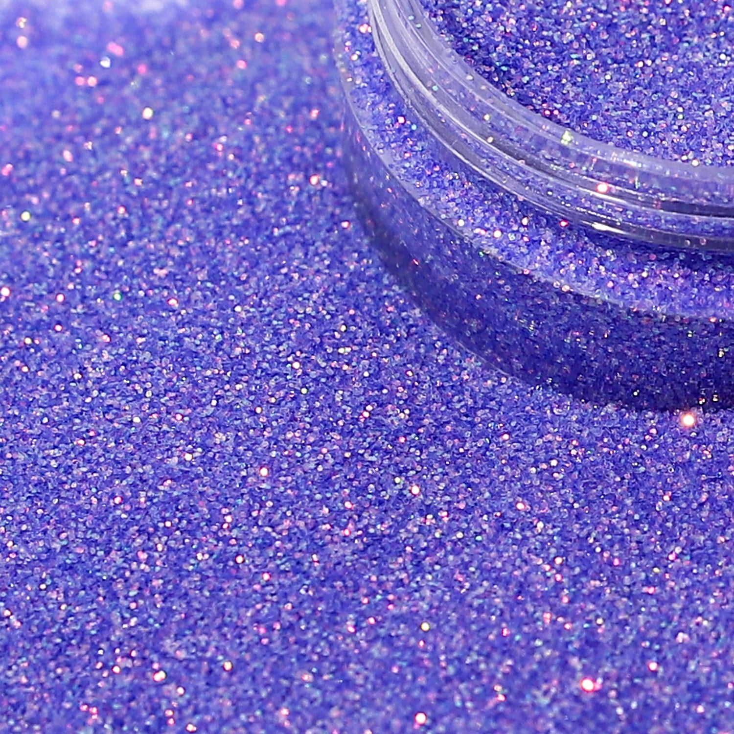 Close-up of purple glitter with a clear container partially filled with glitter.