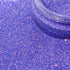 Close-up of purple glitter with a clear container partially filled with glitter.