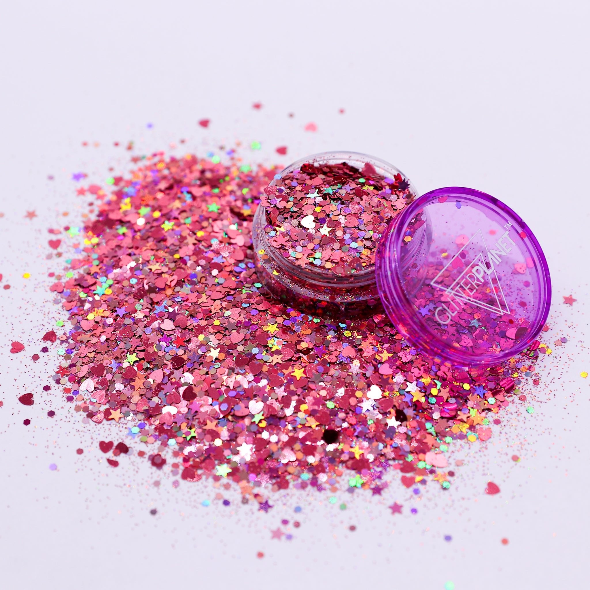 Pink glitter with a purple container on a light gray background