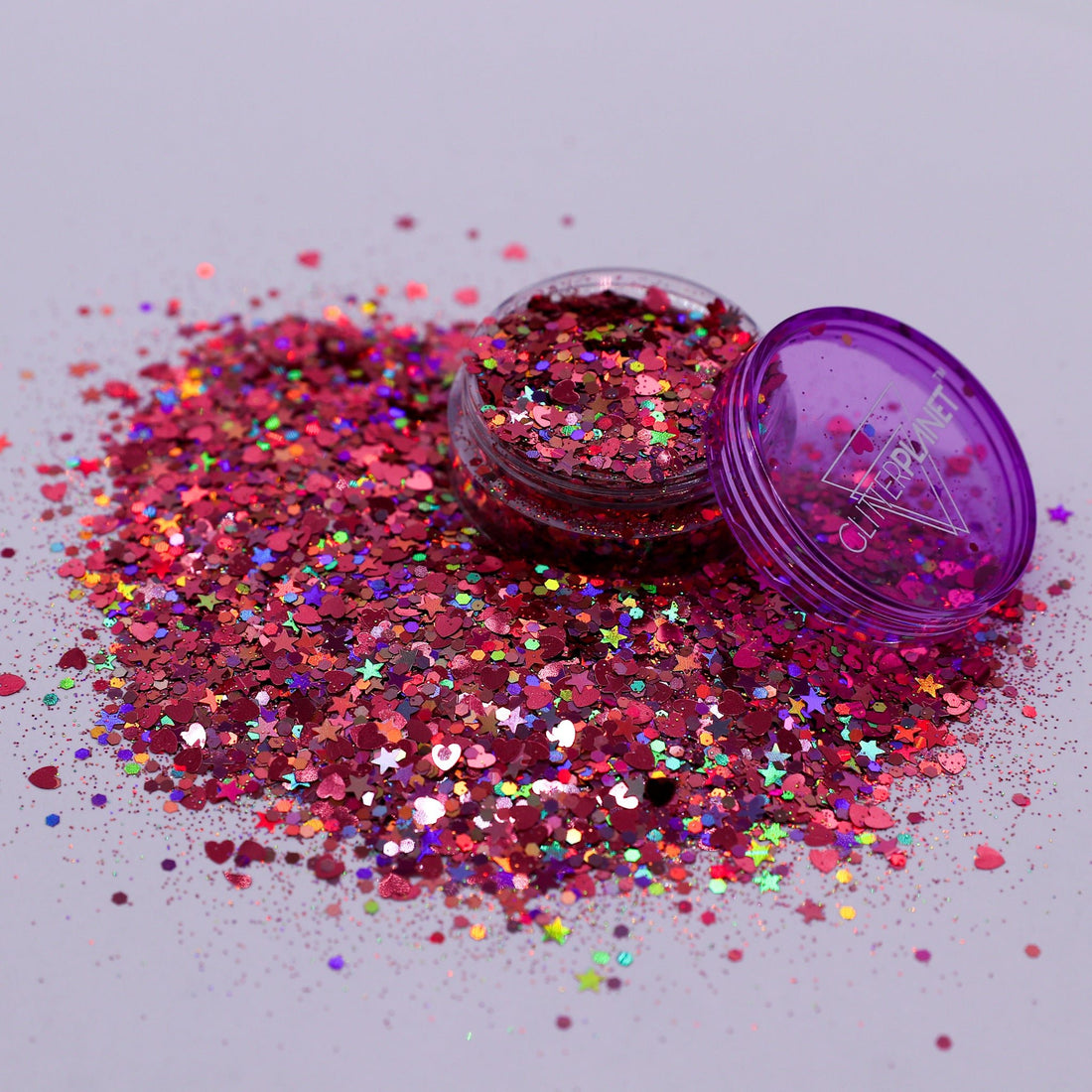 Pink glitter with a purple container on a light gray background