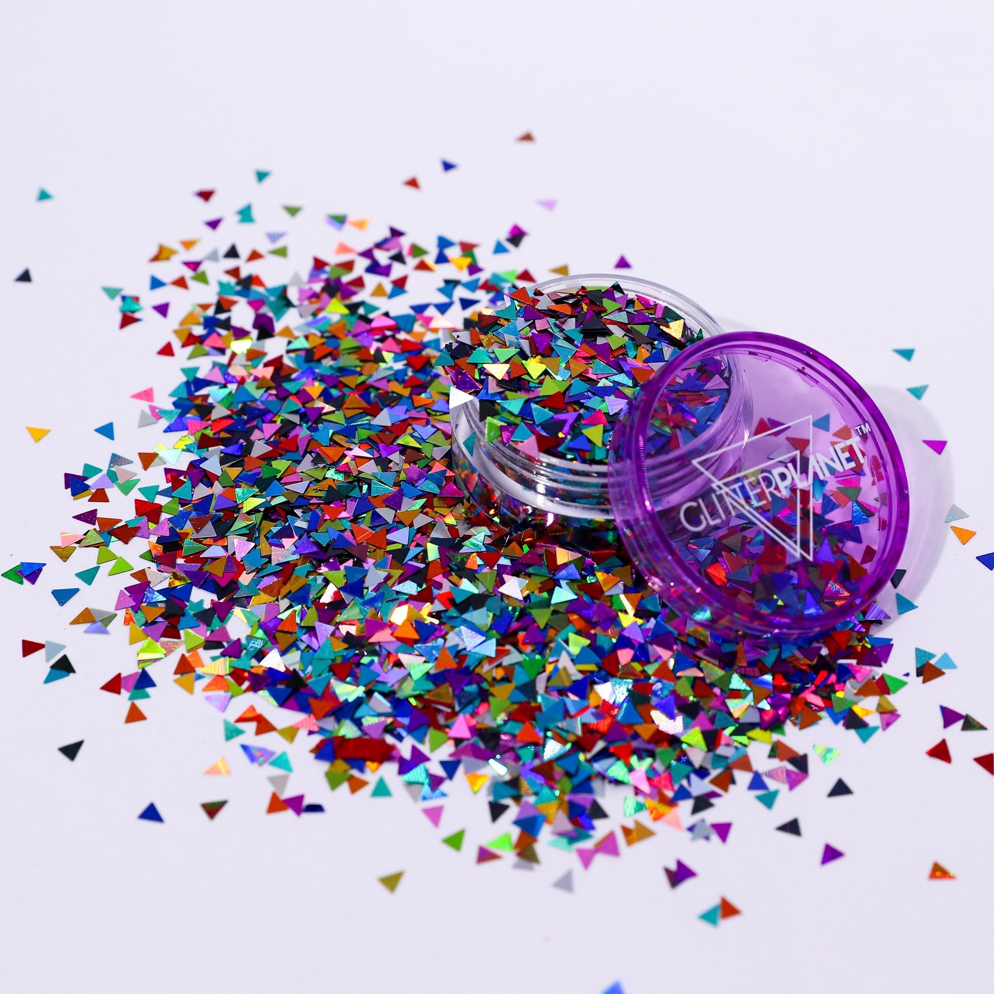 Colorful triangle-shaped glitter spilling out of a container labeled &