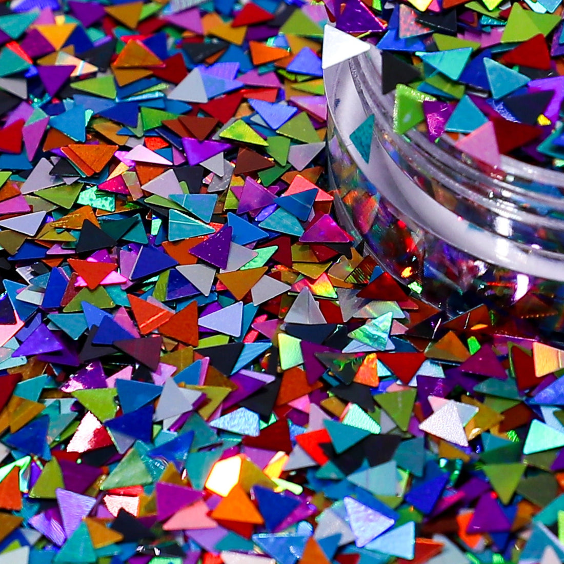 Colorful triangular confetti scattered on a surface with a jar partially filled with more confetti.