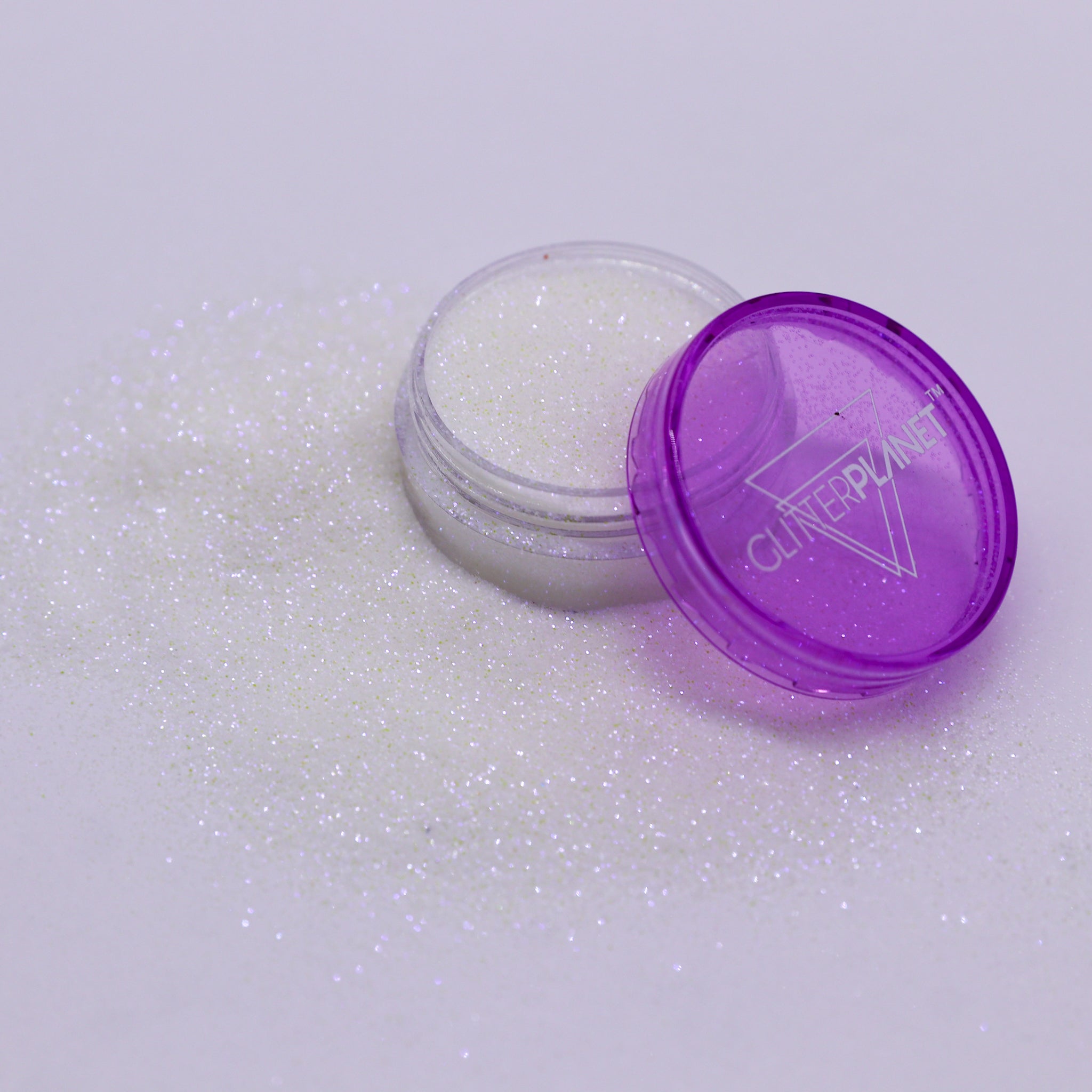 Small open container of glitter with a purple lid on a white background | Glitter Planet