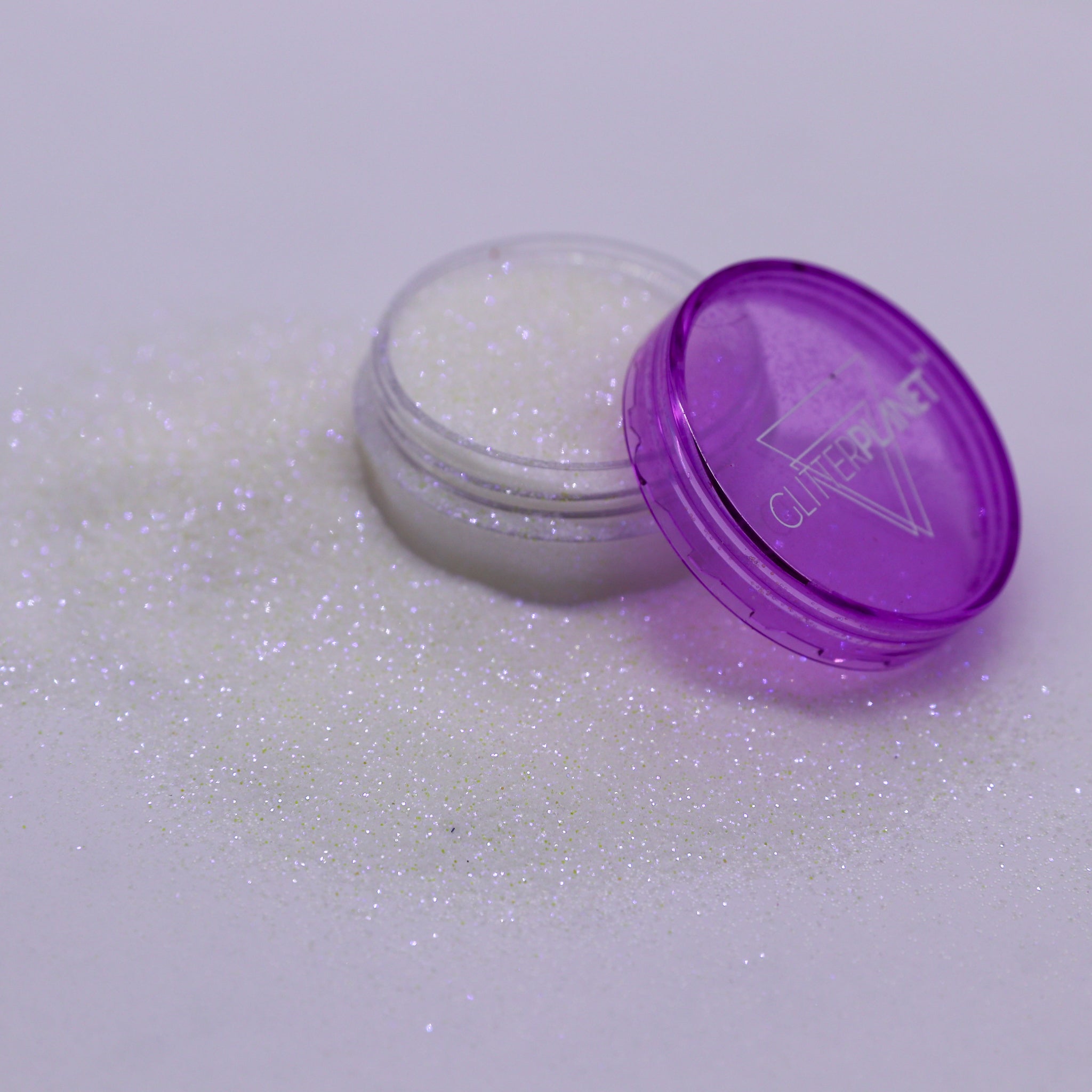 Open container of glitter with a purple lid on a white background | Glitter Planet