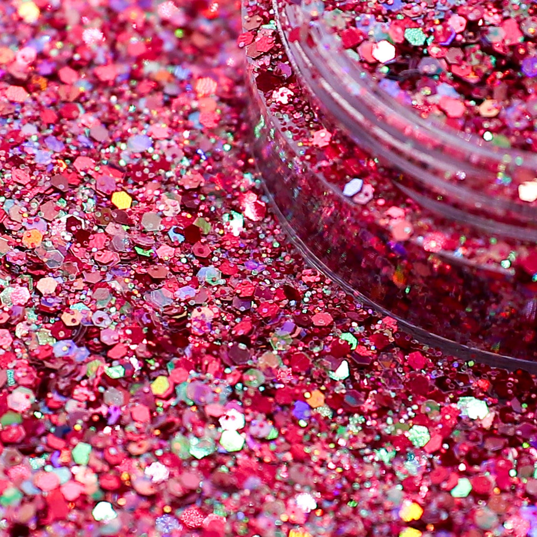 Close-up of pink glitter with a clear container on a pink glitter background