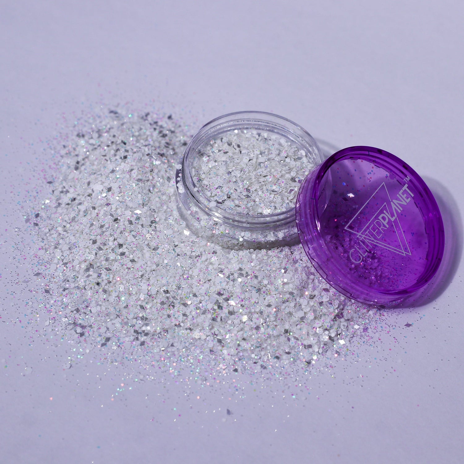 Silver glitter spilling out of a purple container labeled &