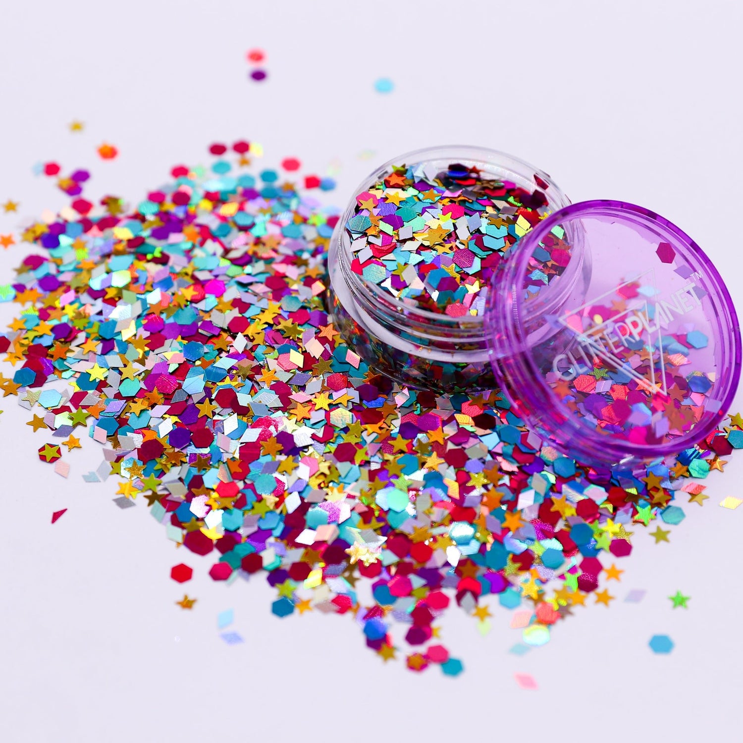 Colorful star-shaped confetti spilling out of a purple container on a white background | Glitter Planet