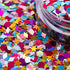 Colorful star-shaped confetti with a container in the background | Glitter Planet